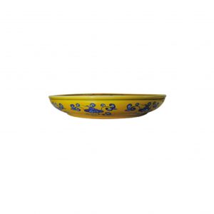 a blue and white dragon dish on yellow ground