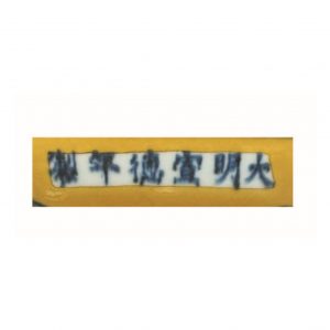 a blue and white dragon dish on yellow ground